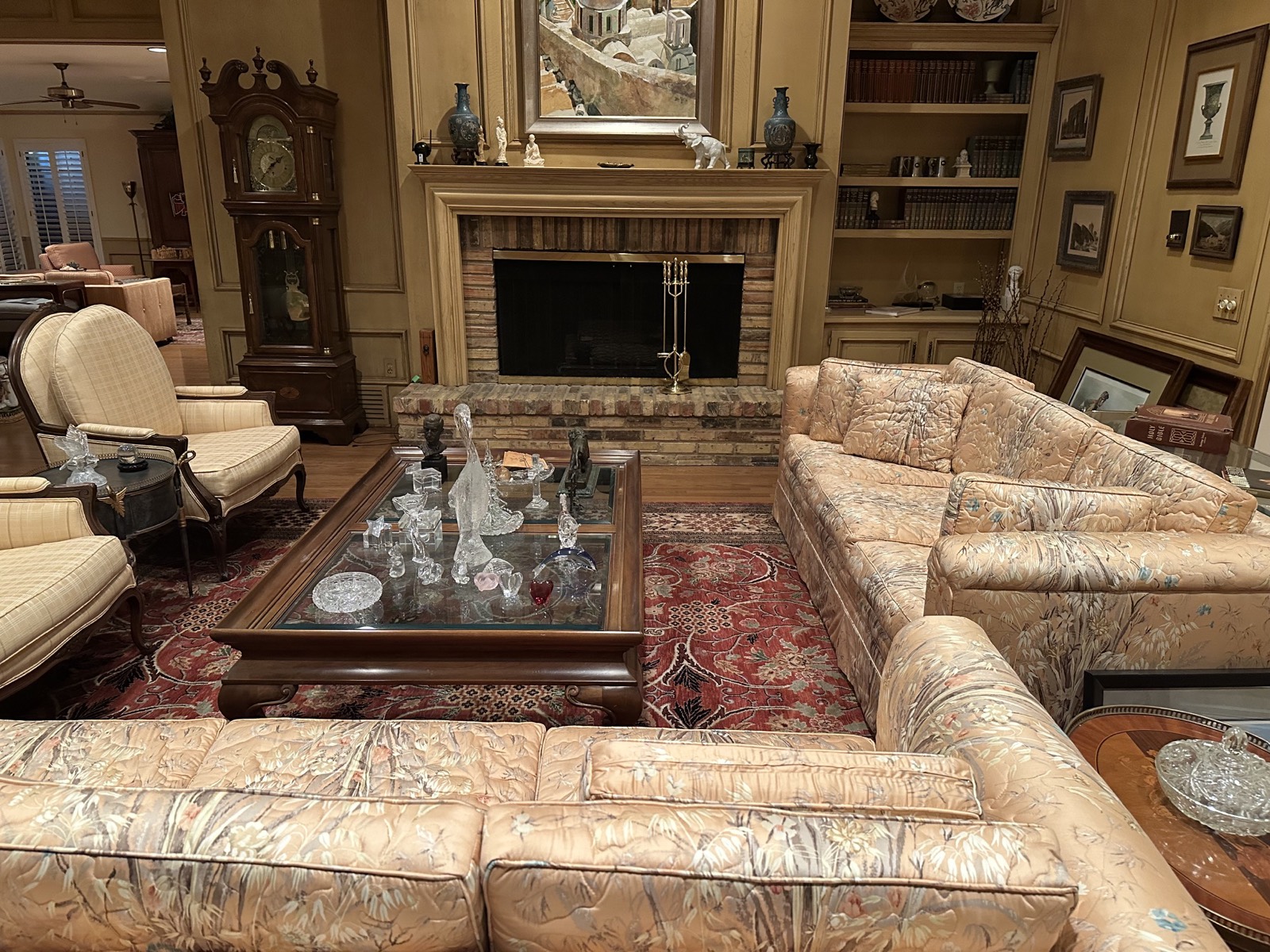 Formal living room with brick fireplace, built-in bookshelves and grandfather clock