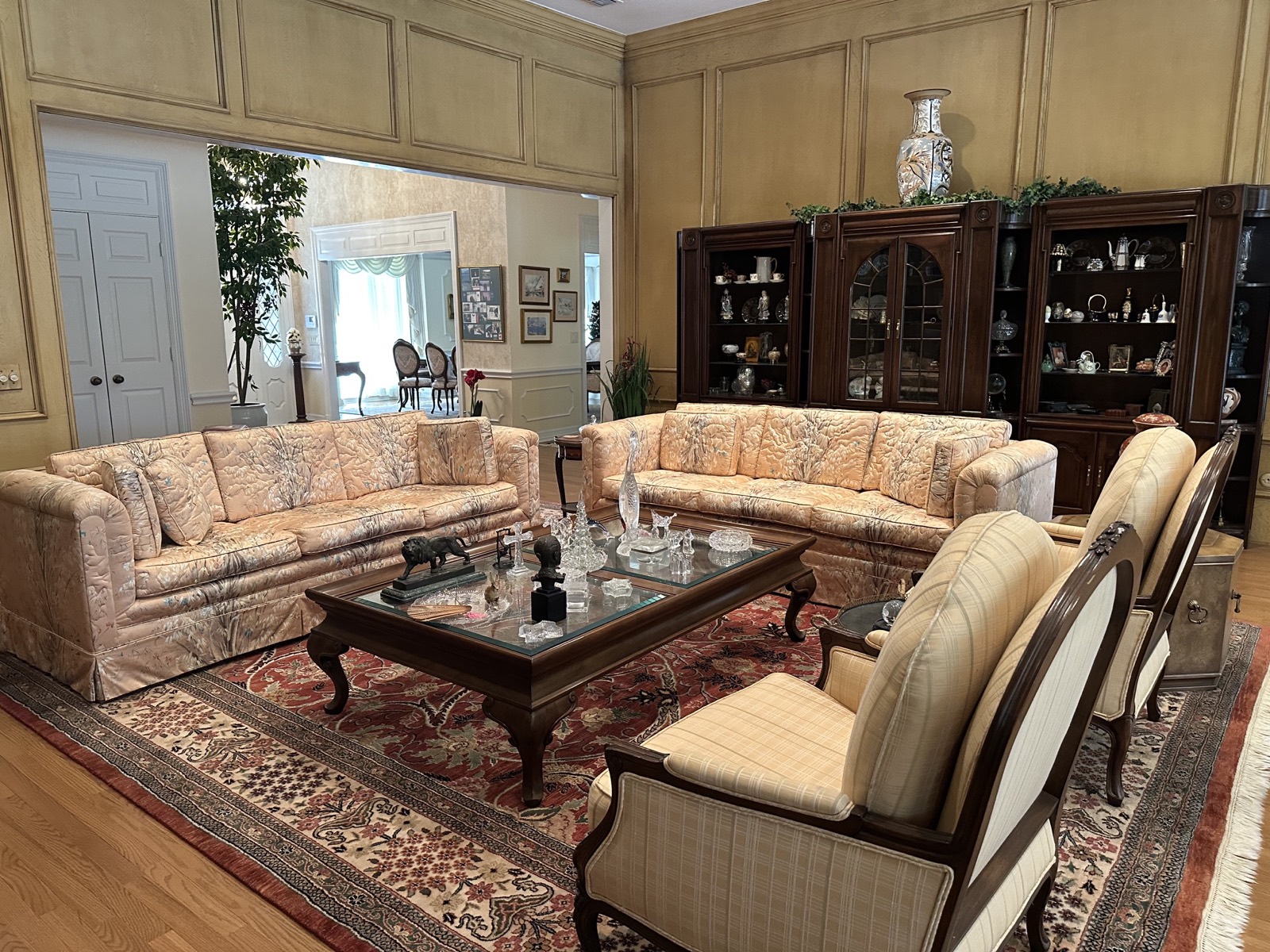 Formal salon with silk sofas and display cabinetry
