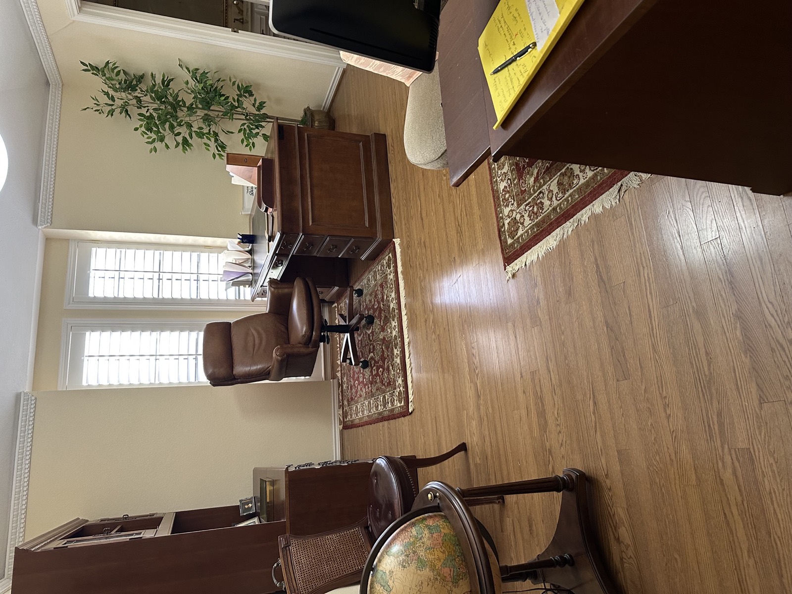 Home office with executive desk, leather chair and globe
