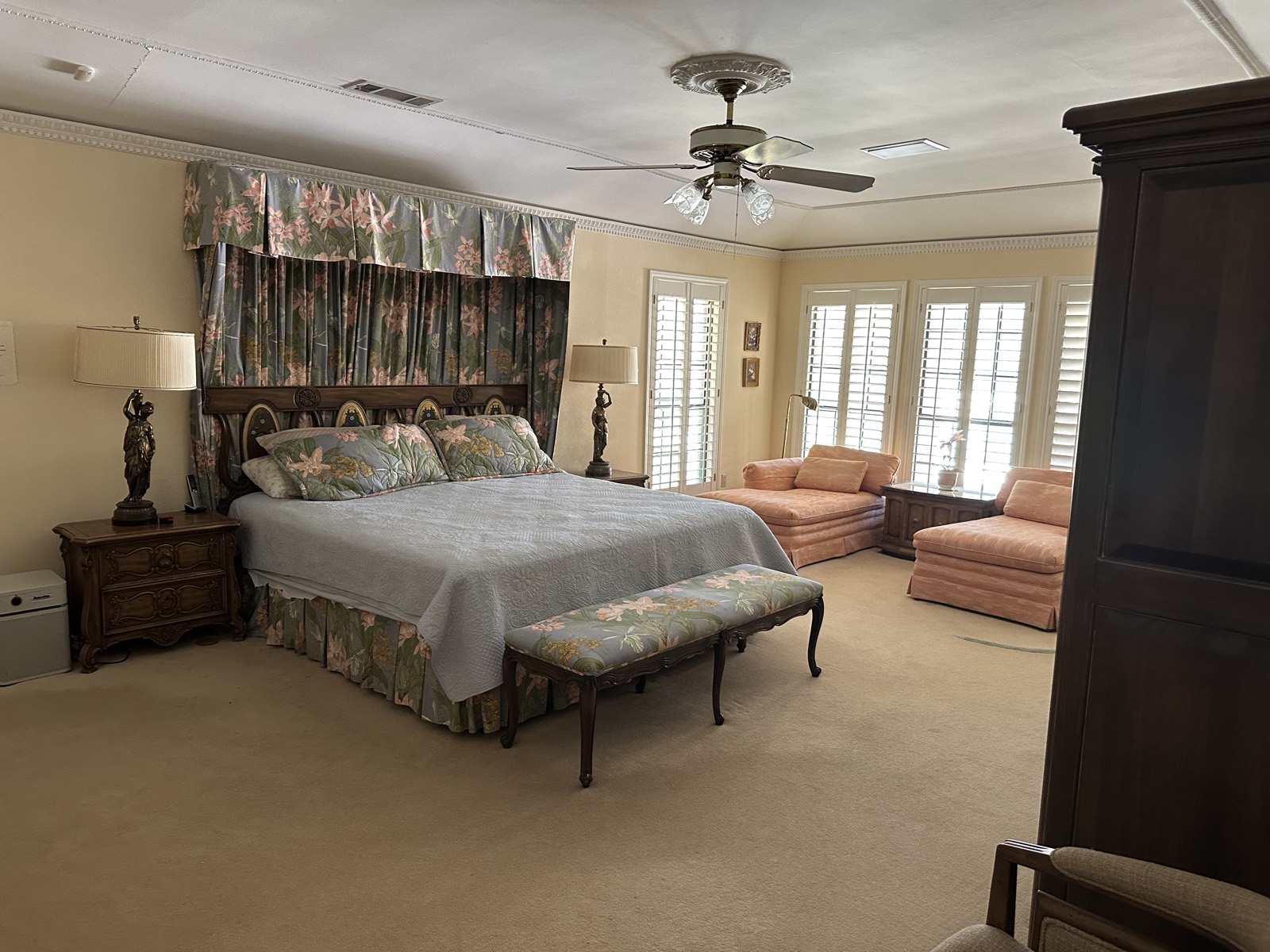 Primary bedroom with king bed, sitting area and armoire
