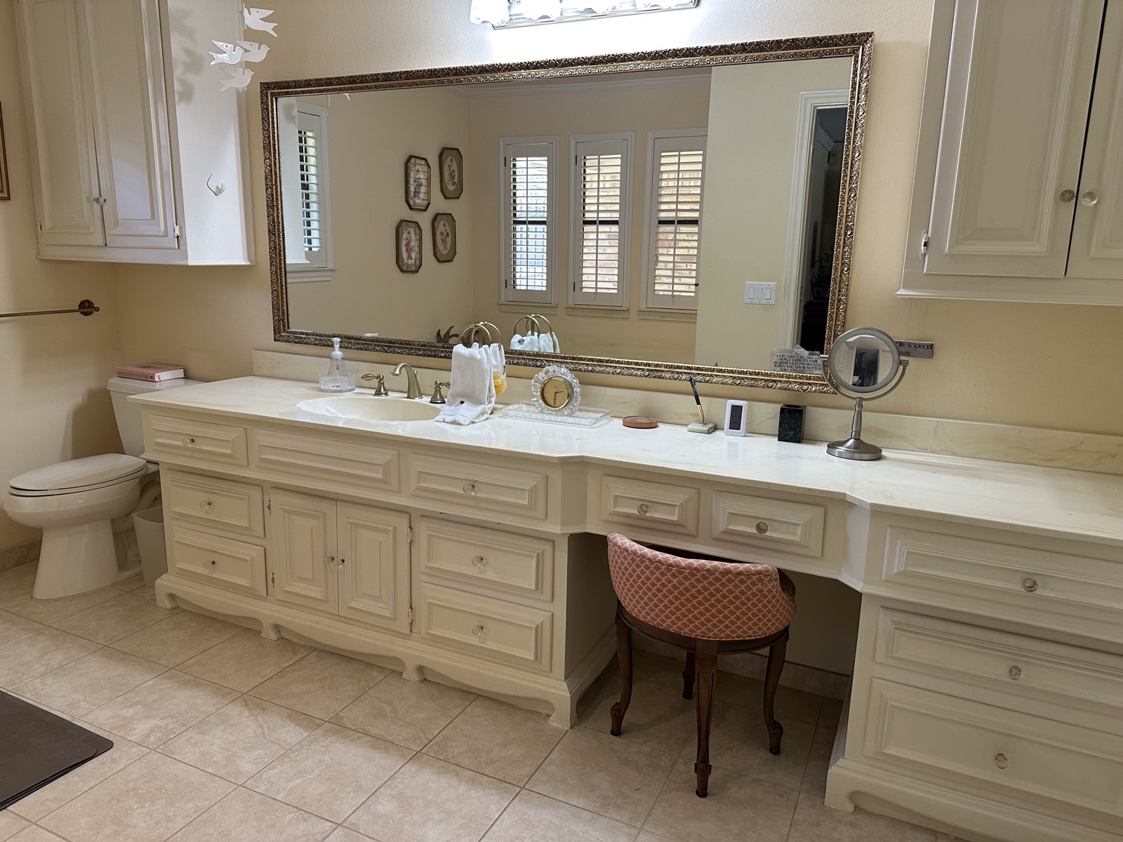 Primary bathroom with marble vanity and seated makeup counter